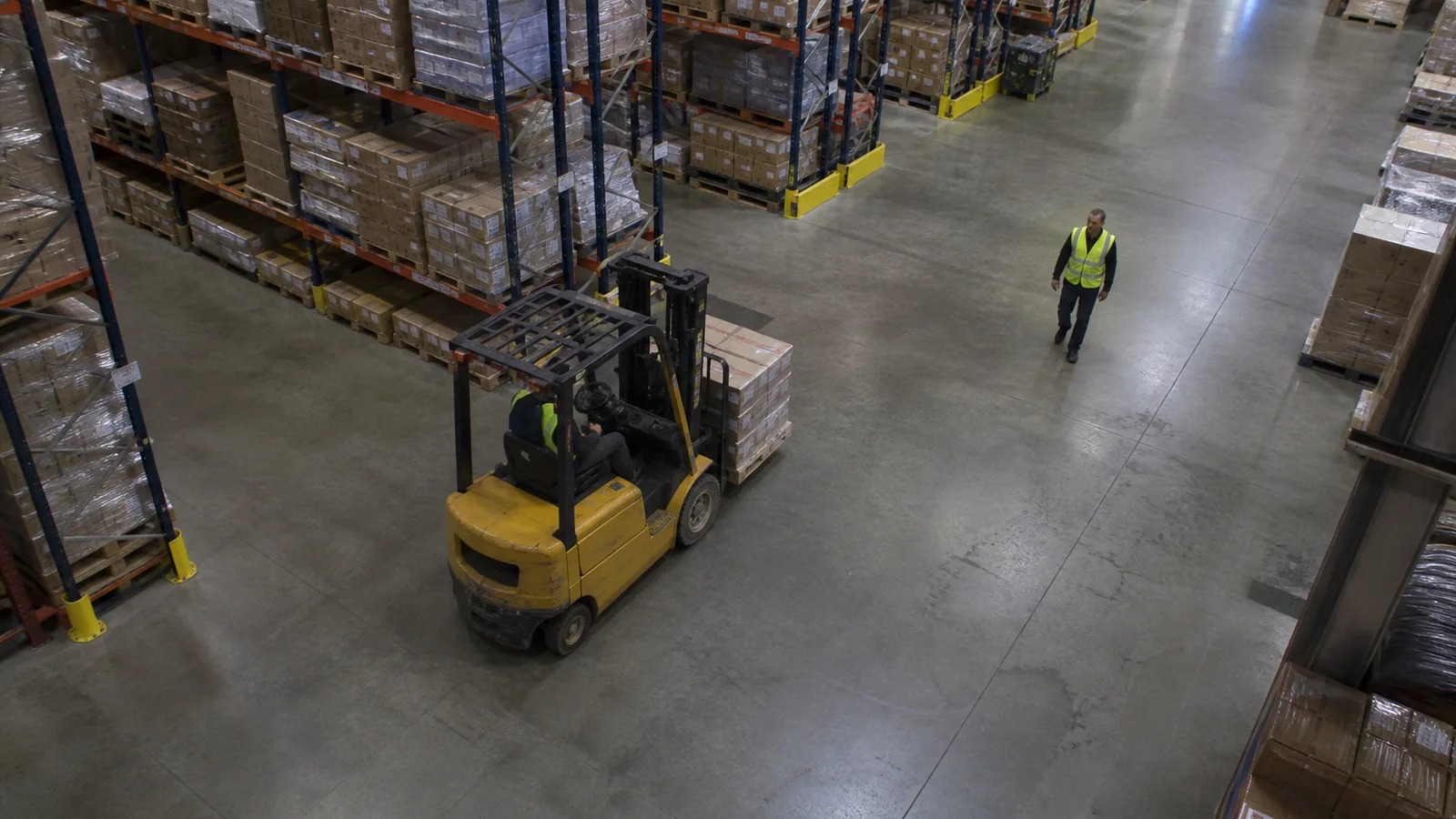 Simulated warehouse security-camera view of a forklift operating near a pedestrian
